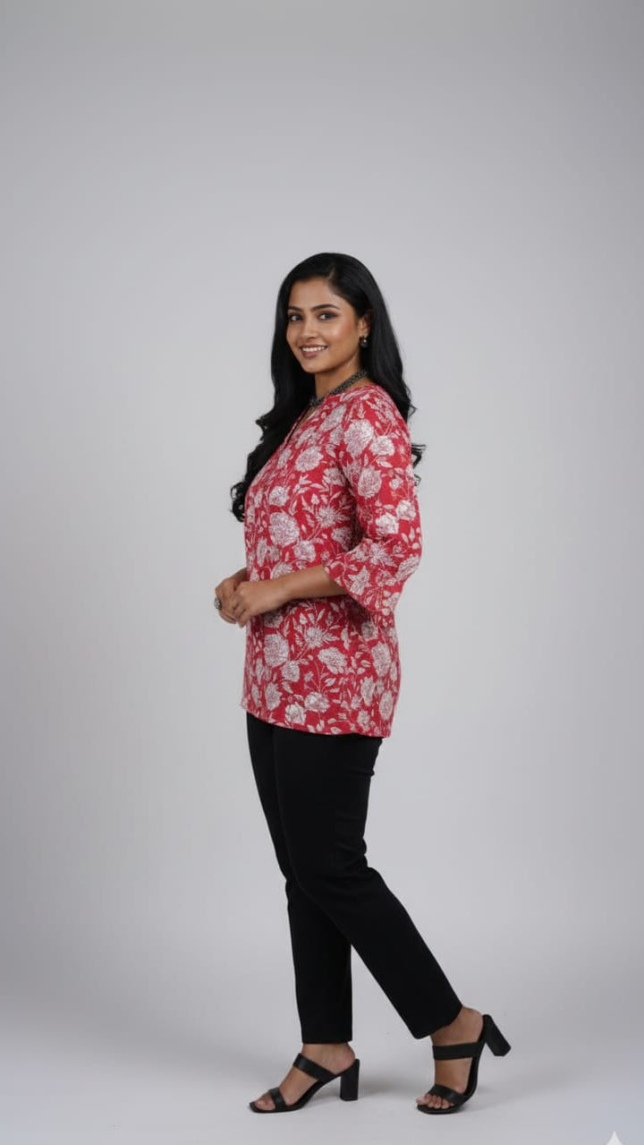 Woman wearing a red floral blouse and black pants on a white background